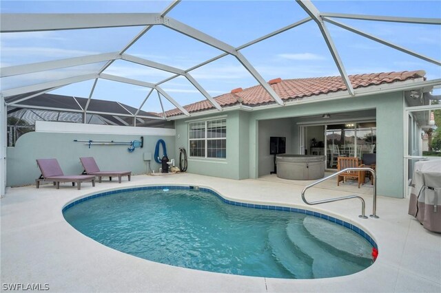 view of pool featuring glass enclosure, ceiling fan, and a patio