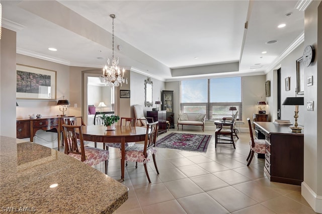 tiled dining area featuring an inviting chandelier, ornamental molding, and a raised ceiling