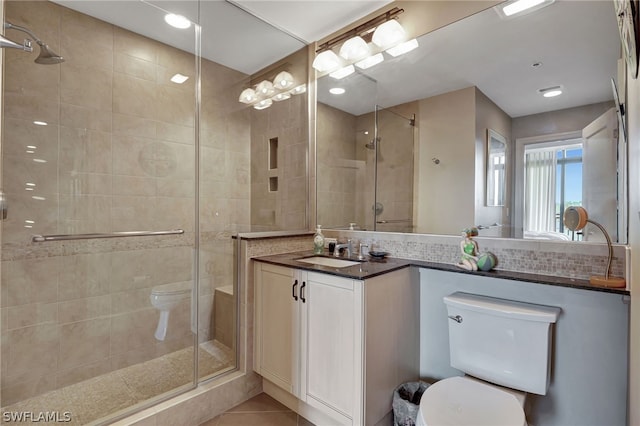 bathroom with an enclosed shower, vanity, toilet, and tile patterned flooring