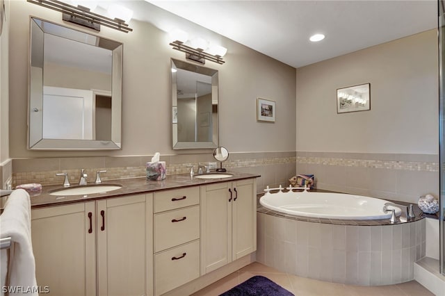 bathroom with tiled bath, tile patterned floors, and vanity