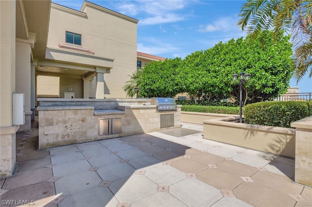 view of patio with an outdoor kitchen and a grill