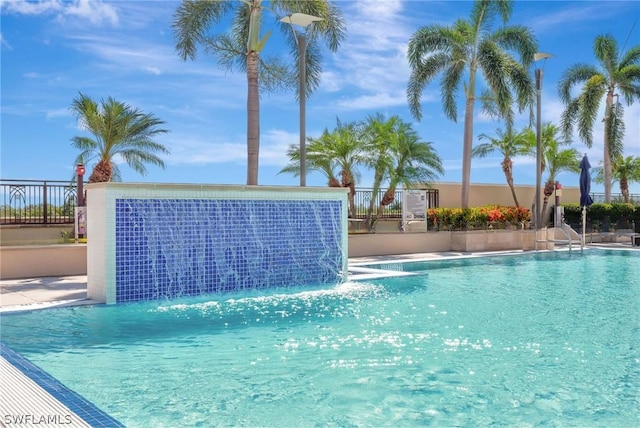 view of swimming pool with pool water feature