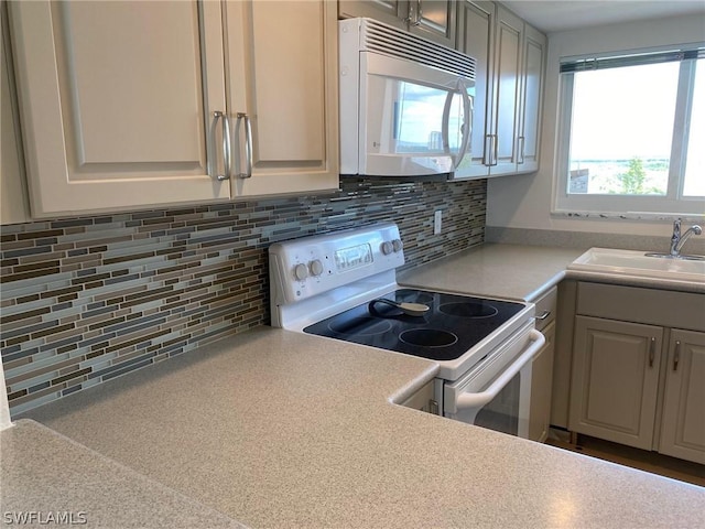 kitchen with decorative backsplash, electric range, and sink