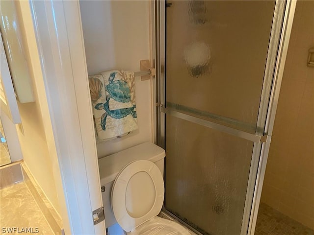 bathroom with toilet and a shower with door