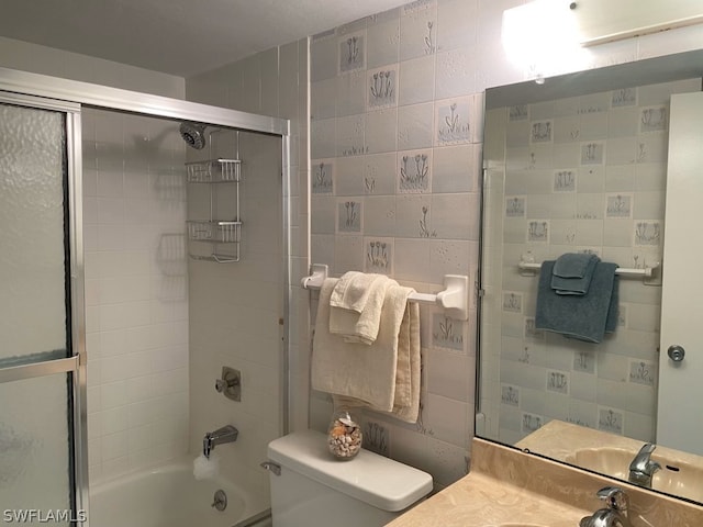 full bathroom with vanity, toilet, shower / bath combination with glass door, and tile walls