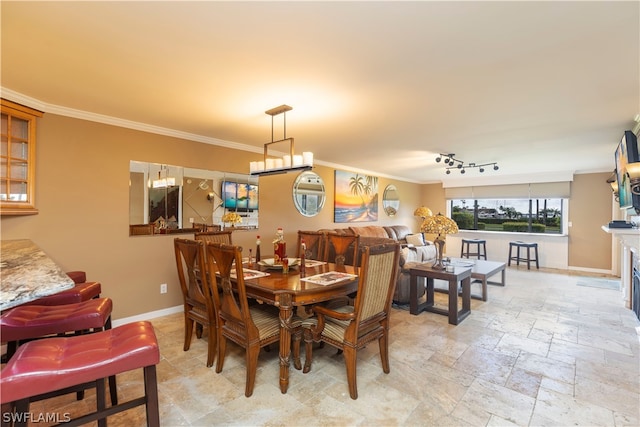 tiled dining room featuring rail lighting and ornamental molding