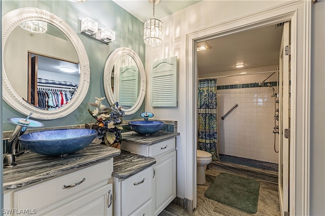 bathroom with walk in shower, a notable chandelier, toilet, vanity, and tile patterned floors