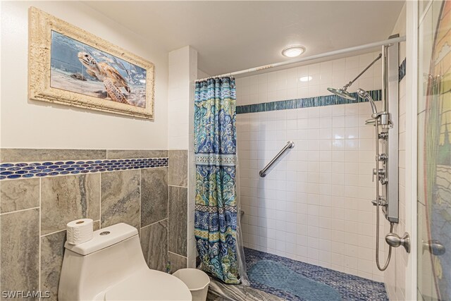 bathroom with tile walls, toilet, and a shower with shower curtain