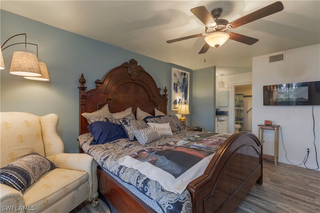 bedroom with connected bathroom, ceiling fan, and hardwood / wood-style floors