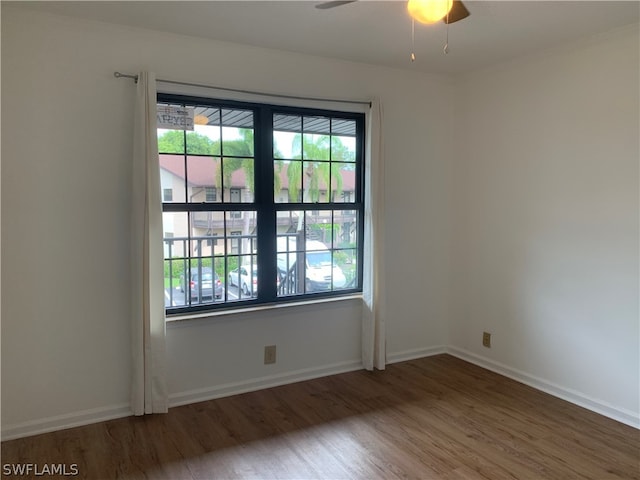 unfurnished room featuring plenty of natural light, ceiling fan, and dark hardwood / wood-style flooring