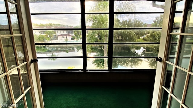 interior space with a healthy amount of sunlight, french doors, and a water view