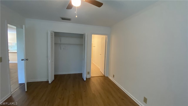 unfurnished bedroom with ceiling fan, a closet, and wood-type flooring