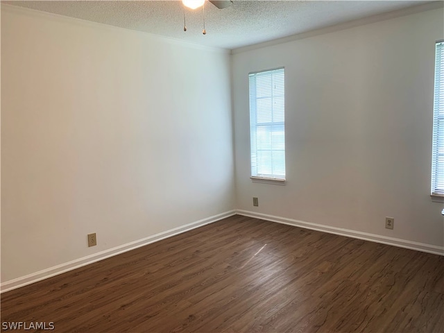 empty room with a textured ceiling, dark hardwood / wood-style floors, and ceiling fan