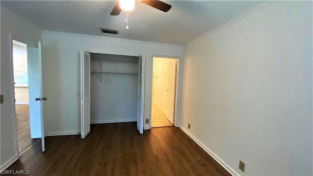 unfurnished bedroom featuring dark wood-type flooring, a closet, and ceiling fan