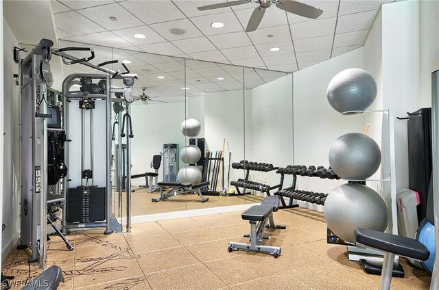 workout area with a paneled ceiling and ceiling fan