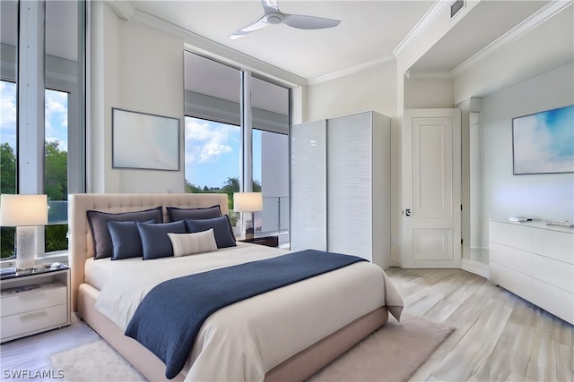 bedroom featuring ceiling fan, light wood-type flooring, crown molding, and multiple windows