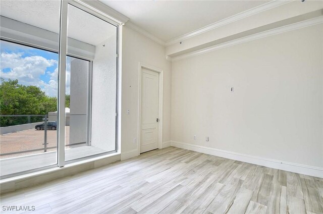 spare room with light hardwood / wood-style flooring and ornamental molding