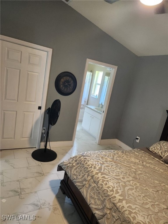 bedroom featuring ensuite bathroom and lofted ceiling