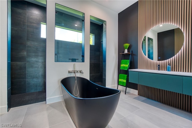 bathroom with a bath to relax in, tile floors, and vanity with extensive cabinet space