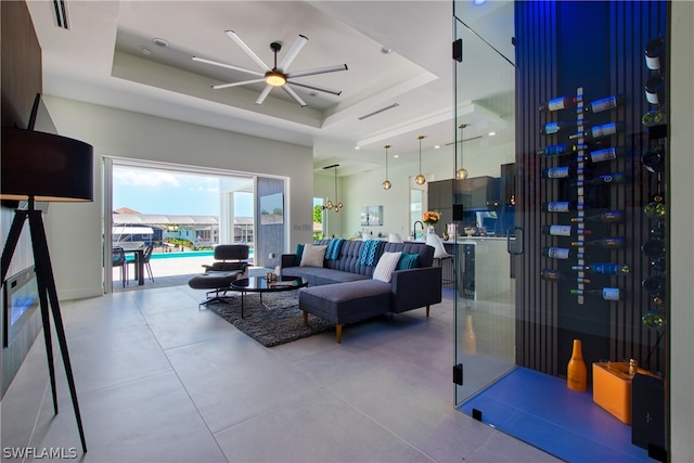 tiled living room featuring a tray ceiling and ceiling fan