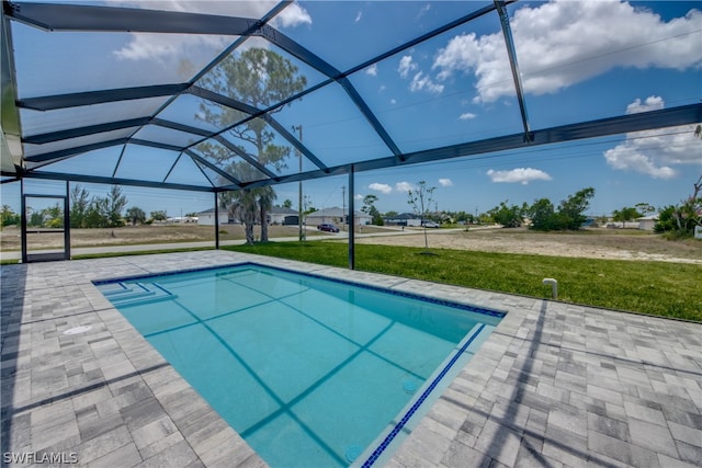 view of pool featuring a patio, a lawn, and a lanai