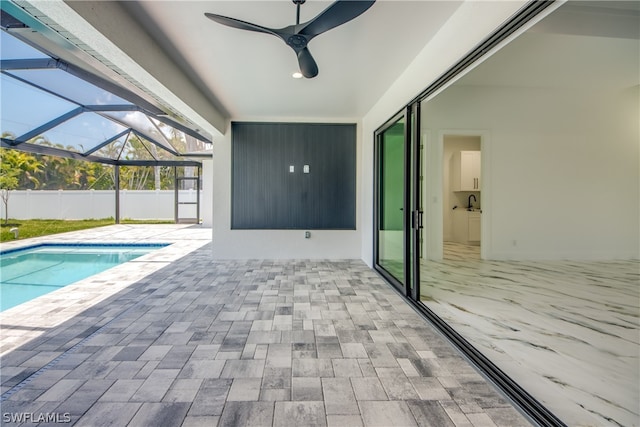 view of pool with ceiling fan, a patio area, and a lanai