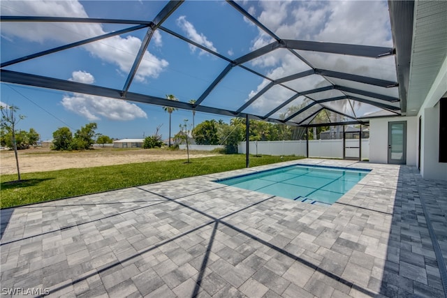 view of pool with a patio, glass enclosure, and a lawn