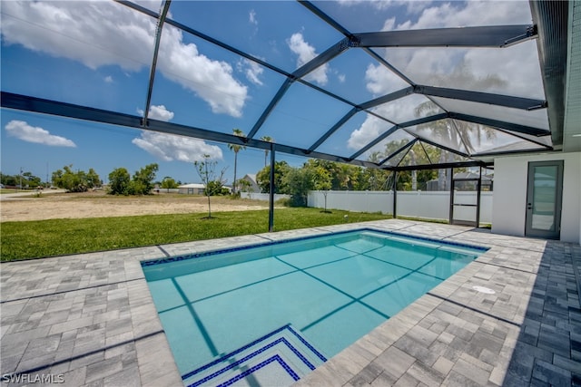 view of pool featuring a patio, glass enclosure, and a yard