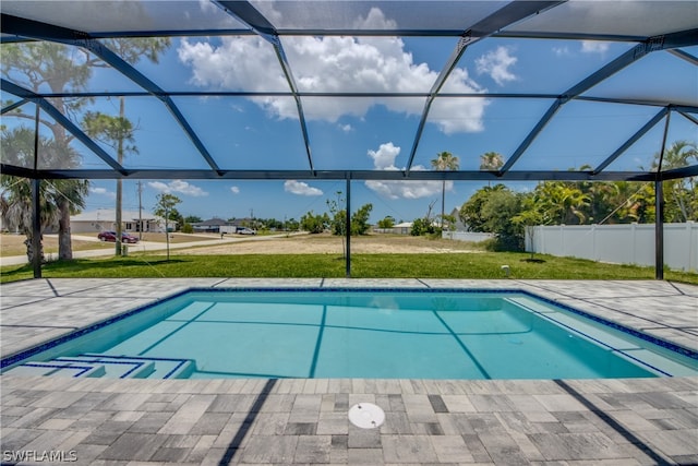 view of swimming pool featuring a yard and a lanai