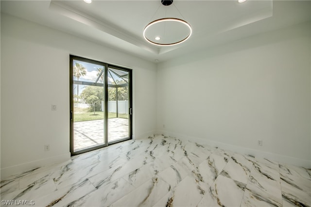 tiled spare room with a tray ceiling