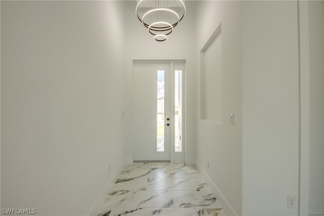 tiled foyer entrance with a chandelier