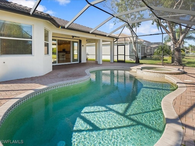 view of swimming pool with ceiling fan, a patio, glass enclosure, and an in ground hot tub