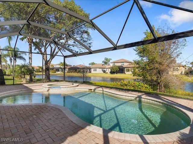 view of pool featuring a patio area, a water view, glass enclosure, and an in ground hot tub