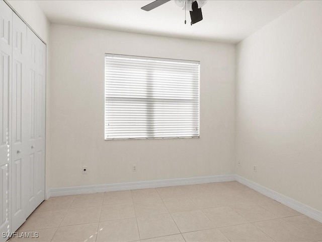 unfurnished bedroom featuring light tile patterned flooring, ceiling fan, and a closet