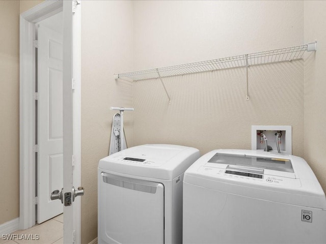 laundry area featuring light tile patterned flooring and washing machine and clothes dryer