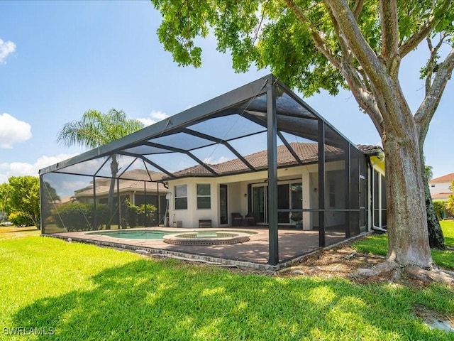 rear view of property with a lanai, a yard, a patio area, and a pool with hot tub