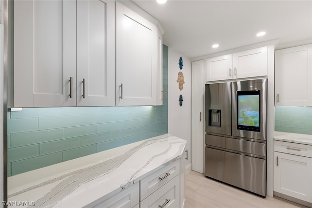 kitchen featuring white cabinetry and stainless steel fridge with ice dispenser