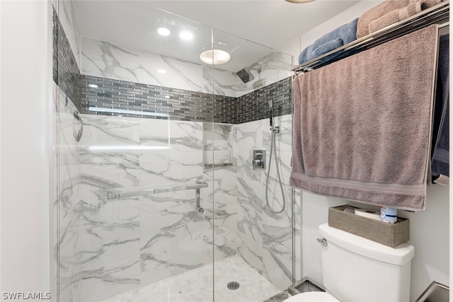 bathroom with toilet and a shower with shower door