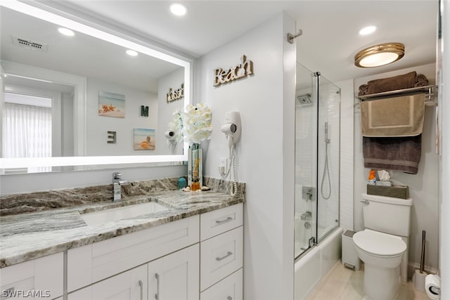 full bathroom featuring vanity, enclosed tub / shower combo, and toilet