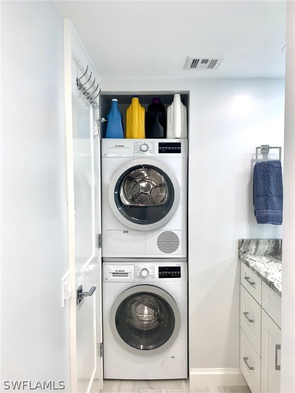 clothes washing area featuring stacked washer / dryer