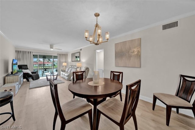 dining space featuring visible vents, ornamental molding, light wood-style floors, baseboards, and ceiling fan with notable chandelier