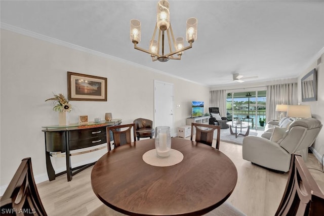 dining space featuring baseboards, ornamental molding, ceiling fan with notable chandelier, and light wood-style floors