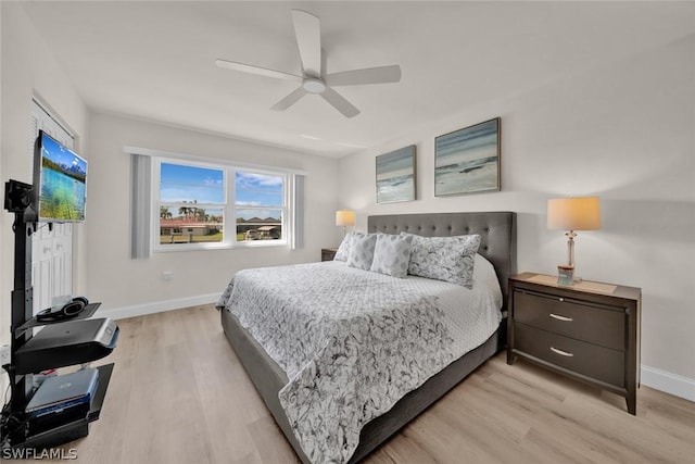 bedroom featuring light wood finished floors, ceiling fan, and baseboards