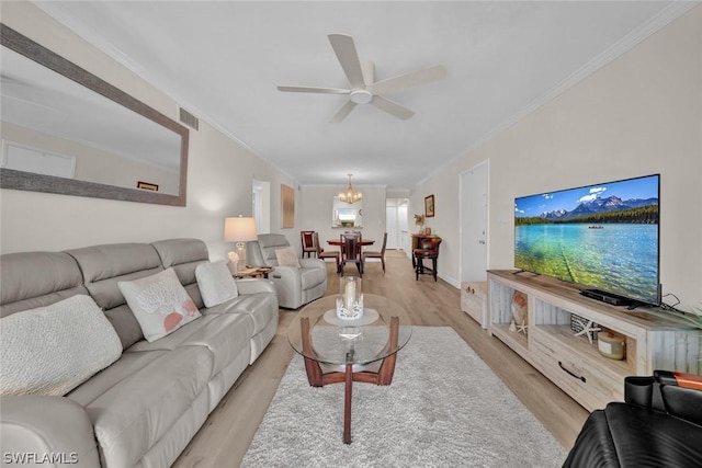 living area featuring ornamental molding, visible vents, light wood-style flooring, and ceiling fan with notable chandelier