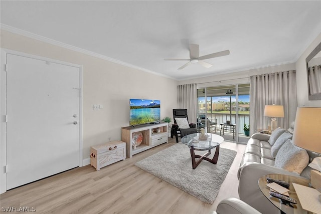 living area with ceiling fan, ornamental molding, and wood finished floors