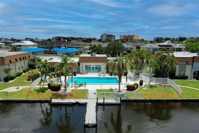 rear view of property with an outdoor pool, a patio area, a fenced backyard, and a water view