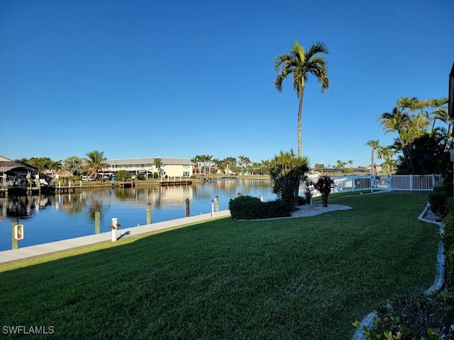 exterior space with a water view and fence