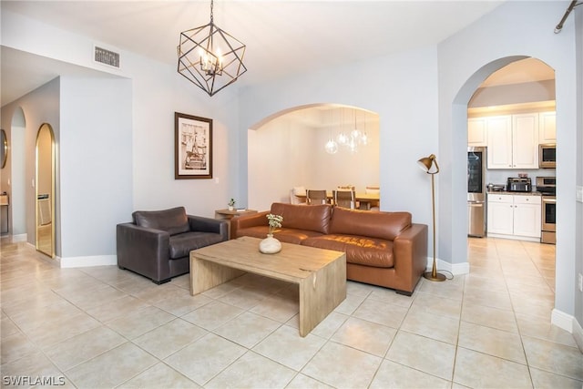 living room featuring a chandelier, light tile patterned floors, and baseboards