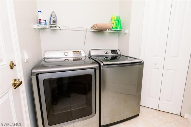 washroom featuring washing machine and clothes dryer and light tile patterned flooring