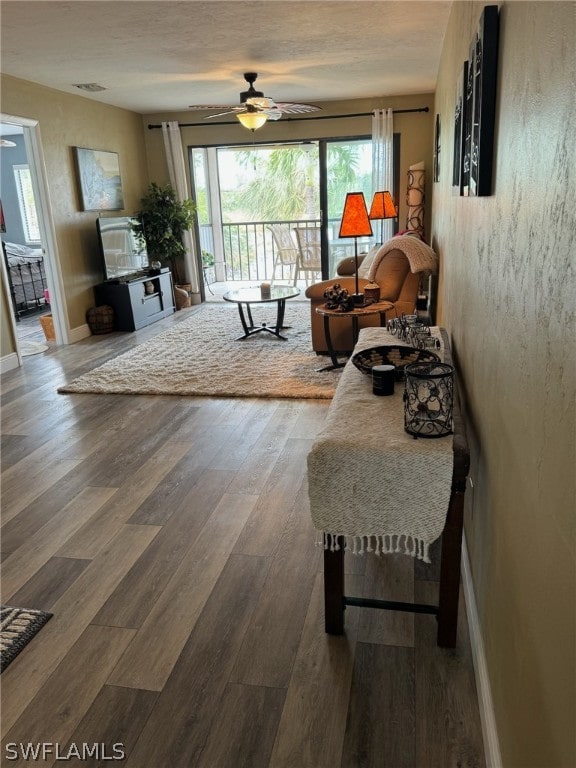 living room featuring ceiling fan and hardwood / wood-style flooring